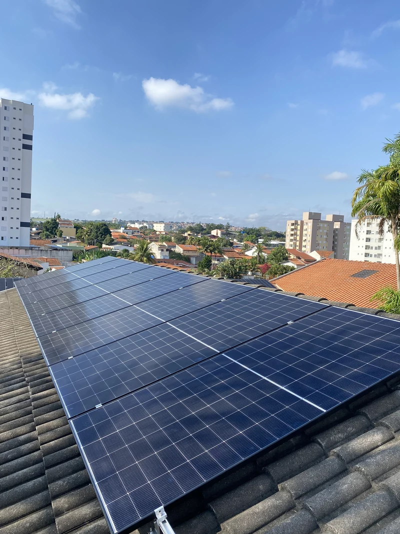 Módulos solares sobre telhado em área urbana